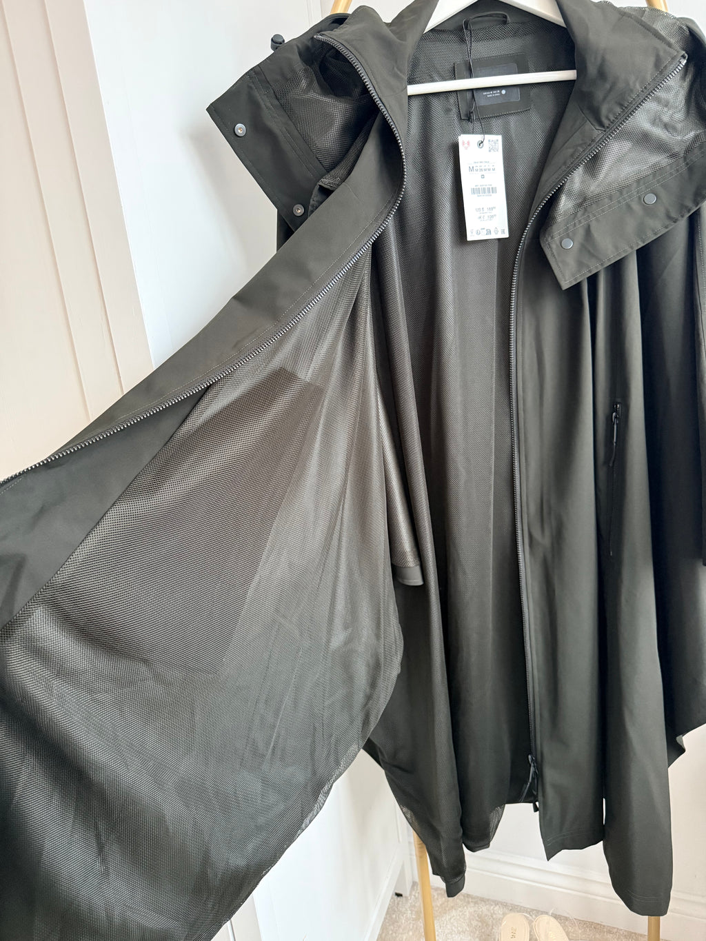     Close-up of Zara khaki cape rain coat showing loose cape-style shape