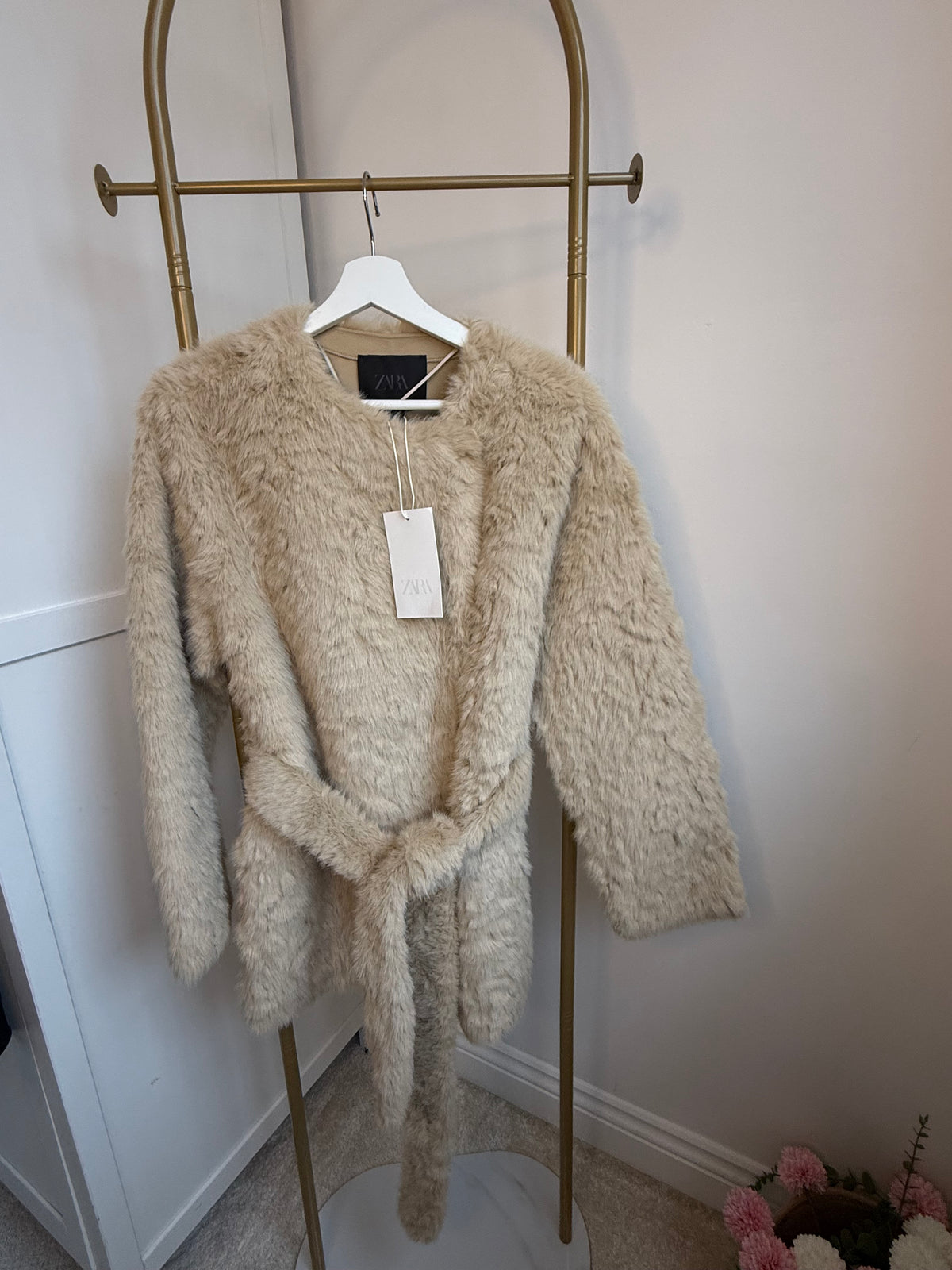     Front view of Zara beige faux fur belted coat on hanger