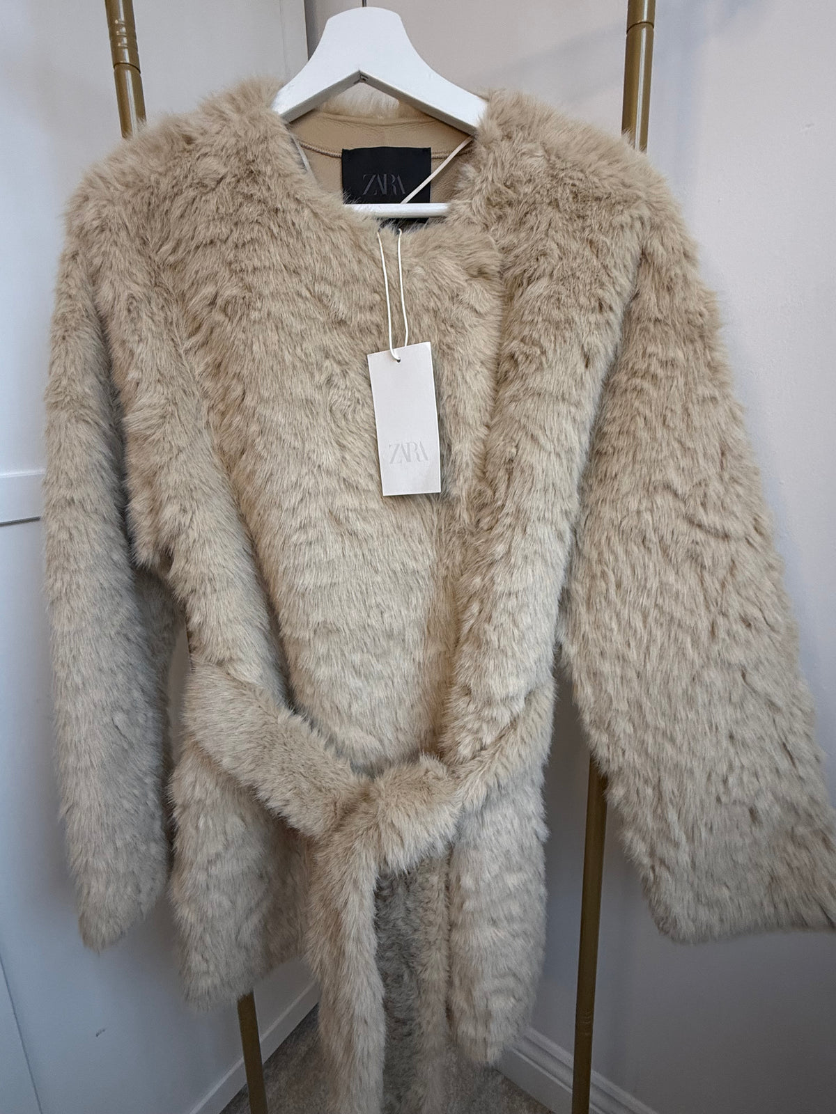     Front view of Zara beige faux fur belted coat with tag and tied belt