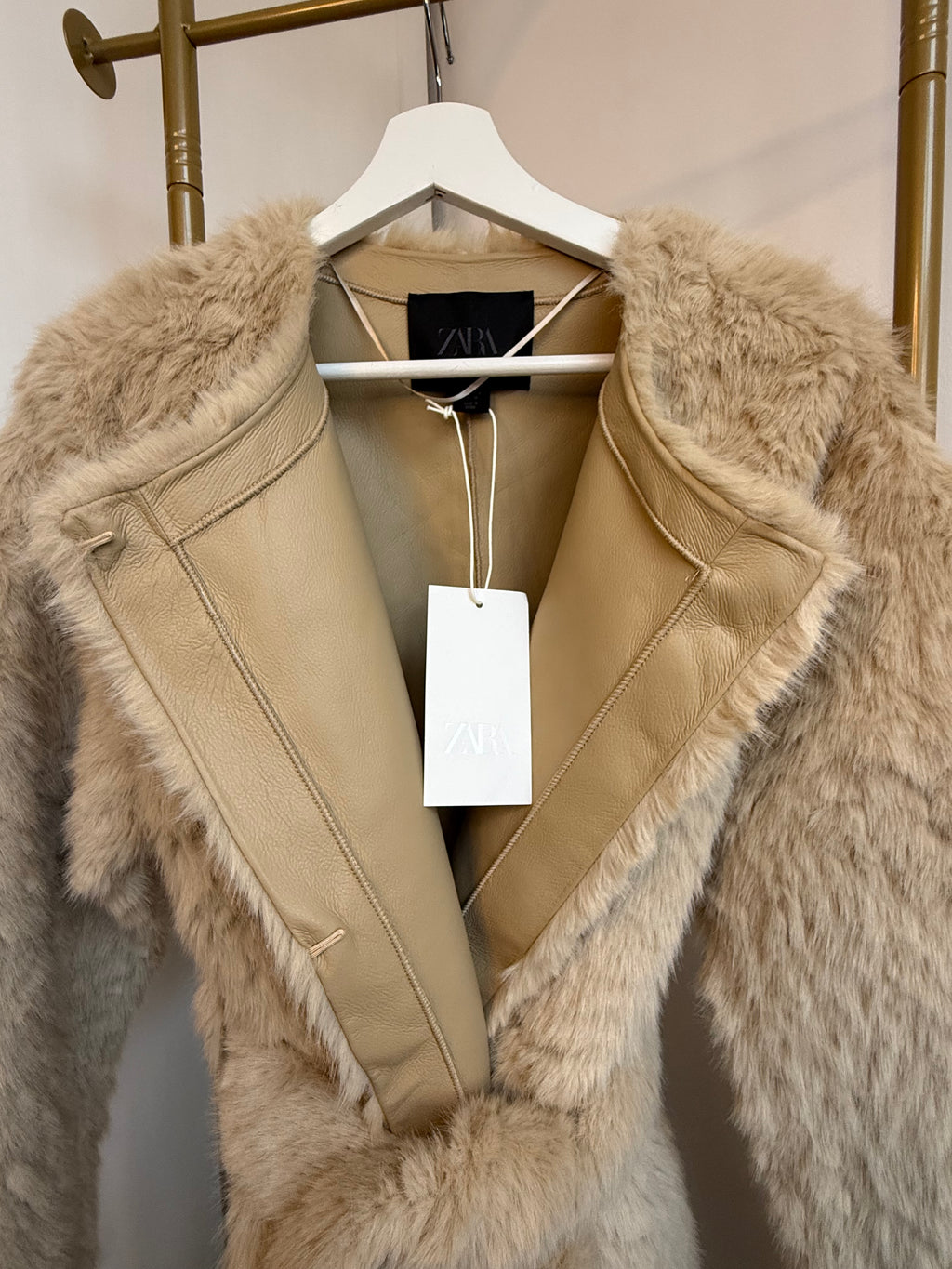     Close-up of Zara beige faux fur coat showing inner lining and collar