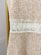     Close-up of beige knit fabric and lace detailing