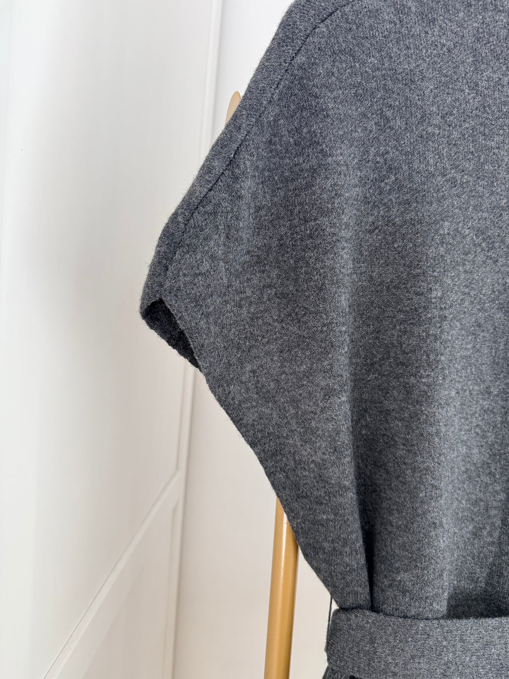     Close-up of grey knit fabric and sleeve detail
