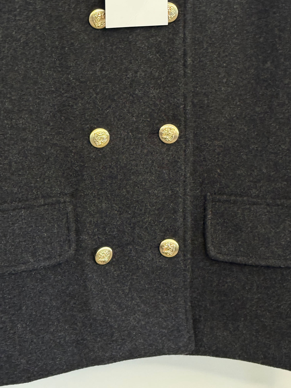    Detail: Close-up of gold buttons and pockets on Zara grey jacket