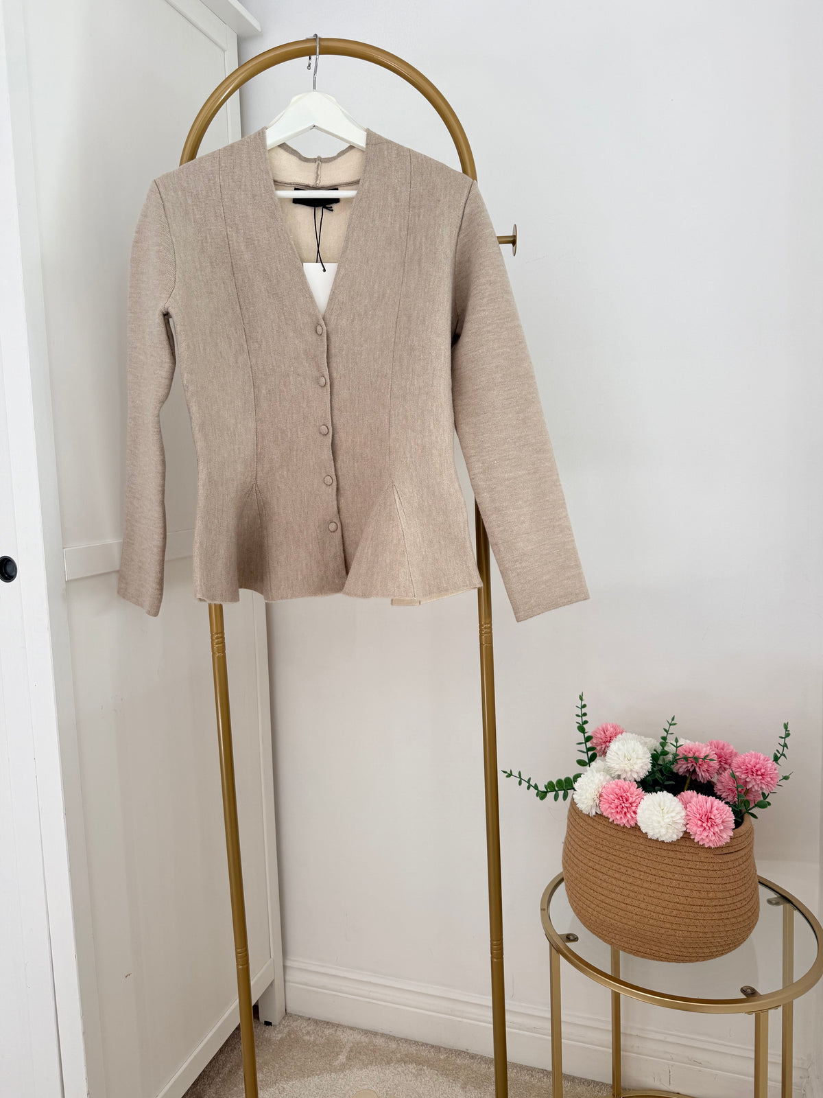    Front view of Zara beige knit peplum cardigan on hanger