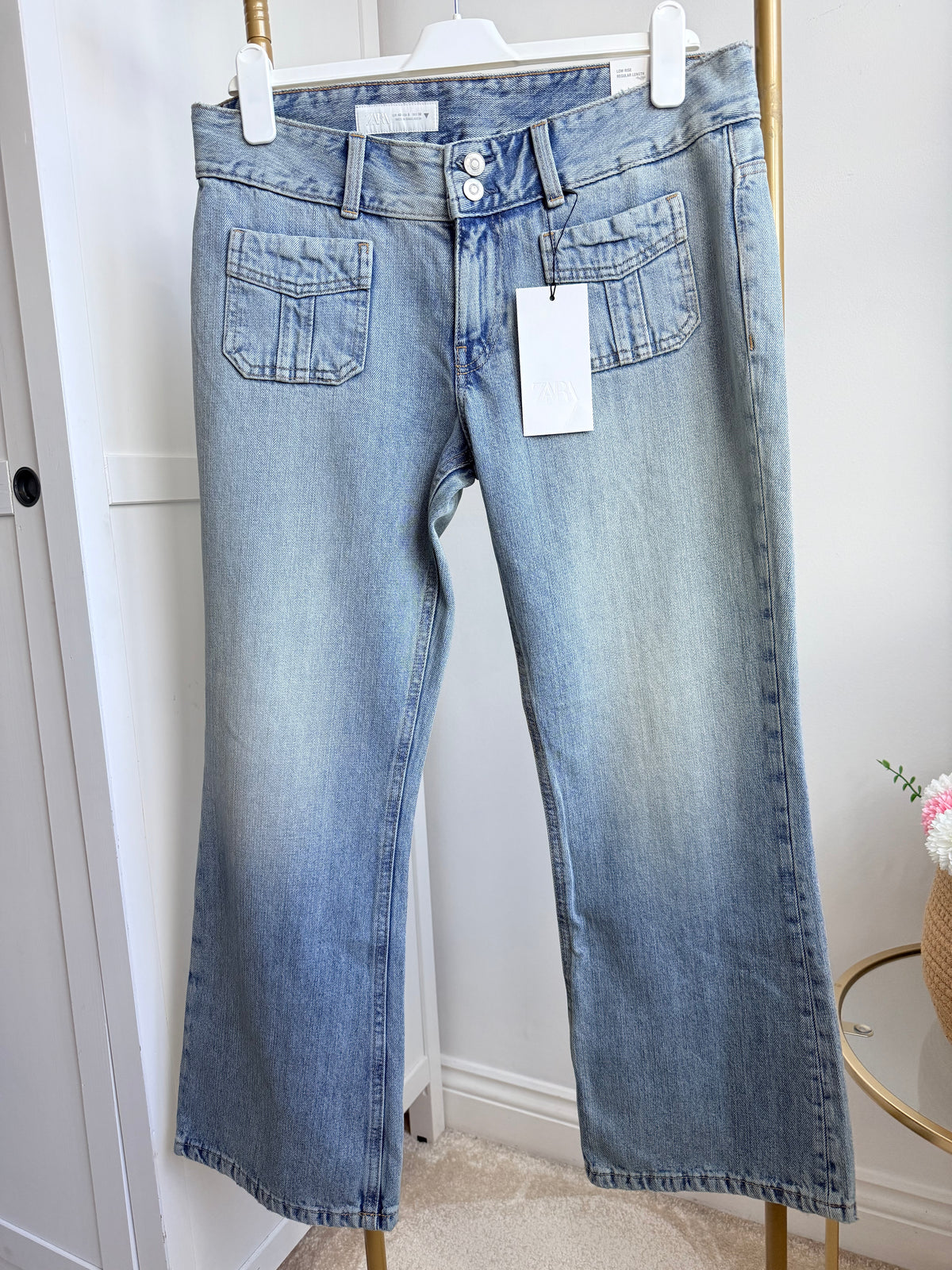     Close front view of Zara blue flared jeans showing denim wash