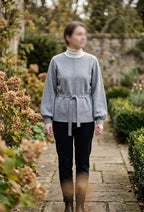     Woman wearing Zara grey belted knit jumper with black trousers outdoors