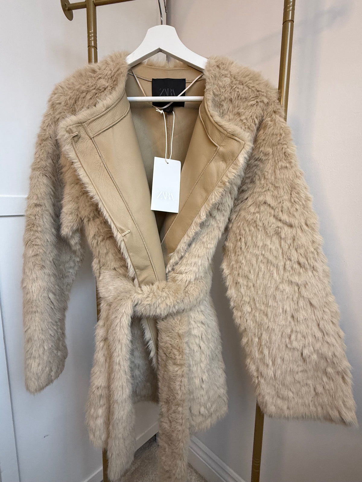     Close-up front view of Zara beige faux fur belted coat and collar