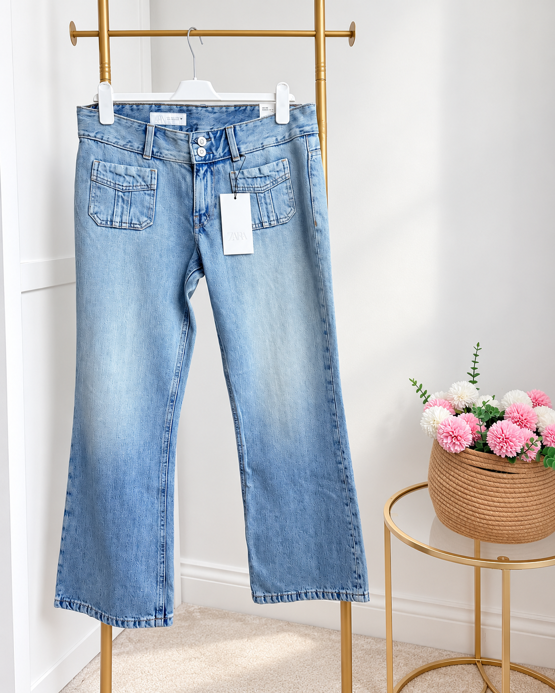     Front view of Zara blue low rise flared jeans on hanger